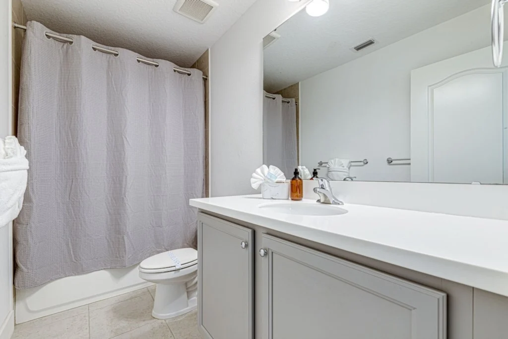 Renovated vacation rental bathroom with new vanity, tile and lighting